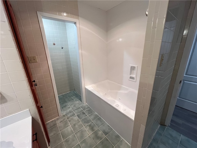 bathroom with tile patterned flooring and a tub to relax in