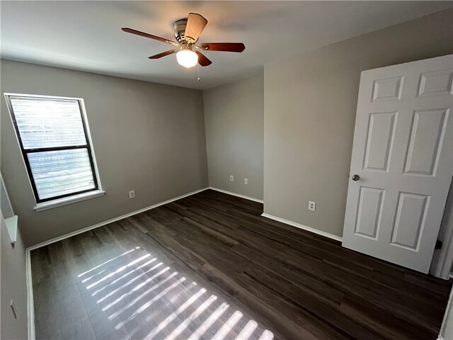 unfurnished room with dark hardwood / wood-style floors and ceiling fan