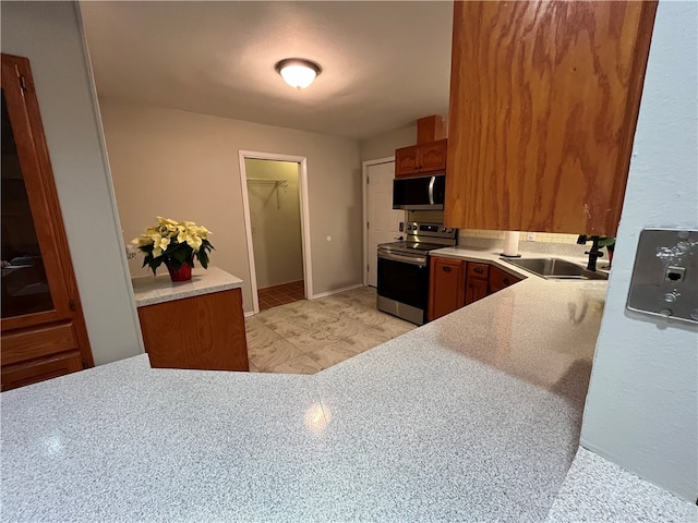 kitchen featuring kitchen peninsula, appliances with stainless steel finishes, and sink