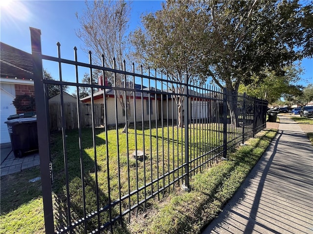 view of gate with a lawn