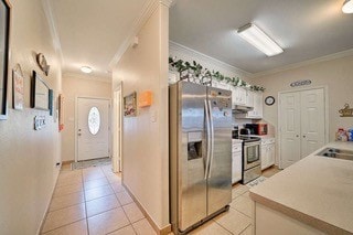 kitchen with ornamental molding, appliances with stainless steel finishes, white cabinetry, and light tile patterned floors