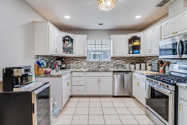 14970 Topgallant St, Corpus Christi, TX 78418 - kitchen featuring appliances with stainless steel finishes, a sink, decorative backsplash, glass insert cabinets, and recessed lighting
