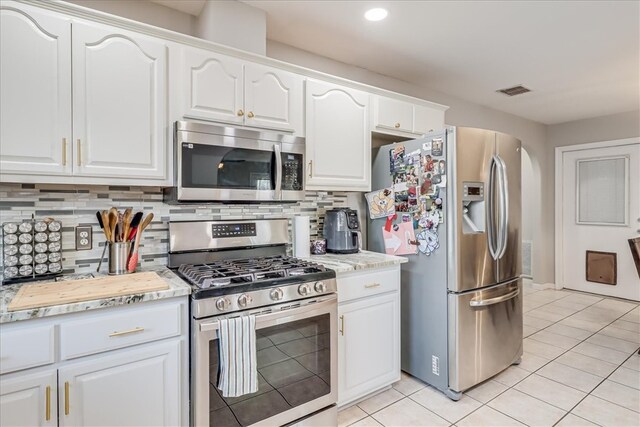 14970 Topgallant St, Corpus Christi, TX 78418 - kitchen featuring appliances with stainless steel finishes, light tile patterned floors, white cabinetry, tasteful backsplash, and recessed lighting