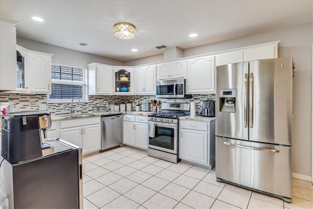 14970 Topgallant St, Corpus Christi, TX 78418 - kitchen with stainless steel appliances, a sink, decorative backsplash, white cabinetry, and glass insert cabinets