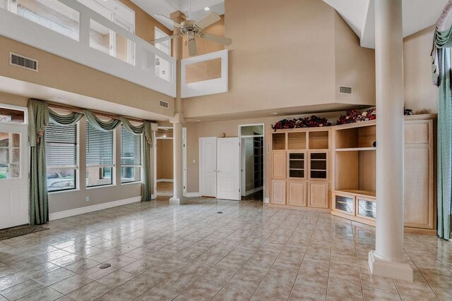 4950 Deer Park, Corpus Christi, TX 78413 - unfurnished living room with decorative columns, a ceiling fan, and a towering ceiling