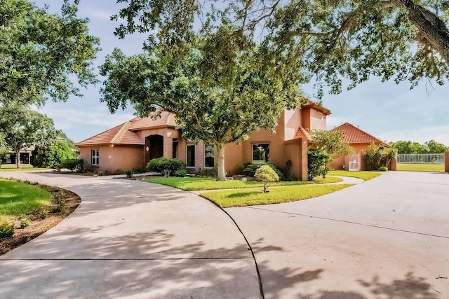 4950 Deer Park, Corpus Christi, TX 78413 - view of front of property with curved driveway, a tiled roof, stucco siding, and a front lawn