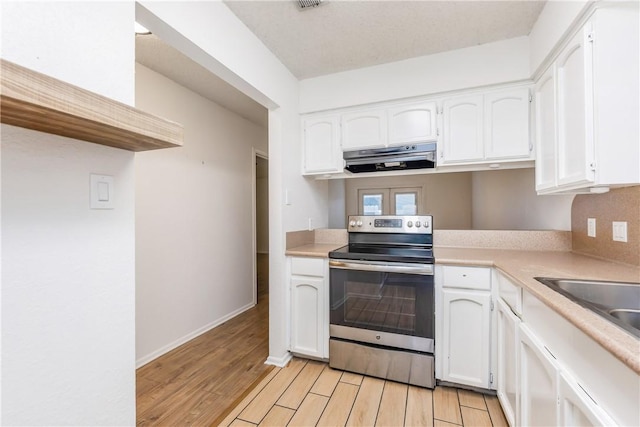 kitchen with white cabinets, light wood-type flooring, stainless steel range with electric stovetop, and exhaust hood