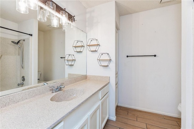 full bathroom featuring baseboards, walk in shower, toilet, wood finished floors, and vanity