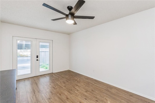 unfurnished room with ceiling fan, french doors, light wood-type flooring, and baseboards