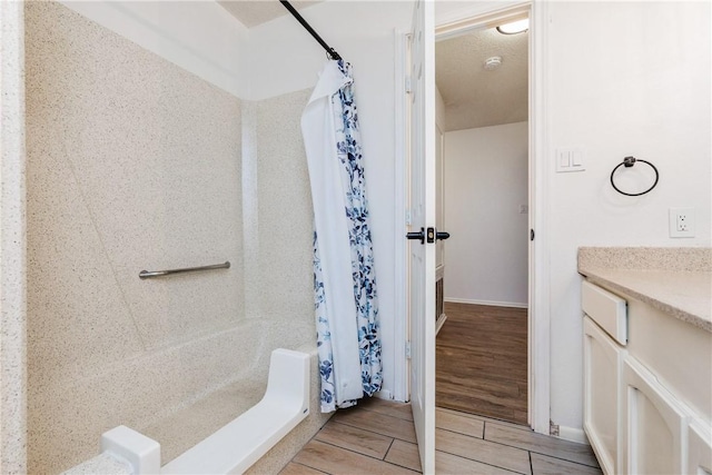 bathroom with vanity, wood finish floors, and a shower with curtain