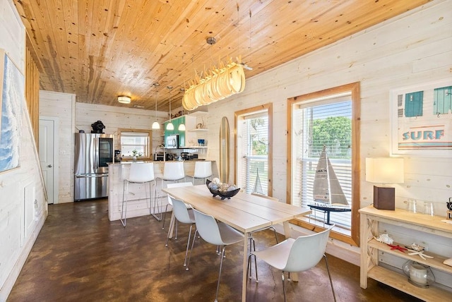 2120 S 11th St Unit 404, Port Aransas, TX 78373 - dining space with wooden ceiling, concrete floors, and wooden walls