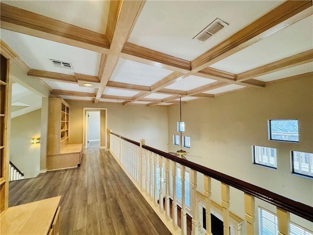 corridor with coffered ceiling, wood-type flooring, and beamed ceiling