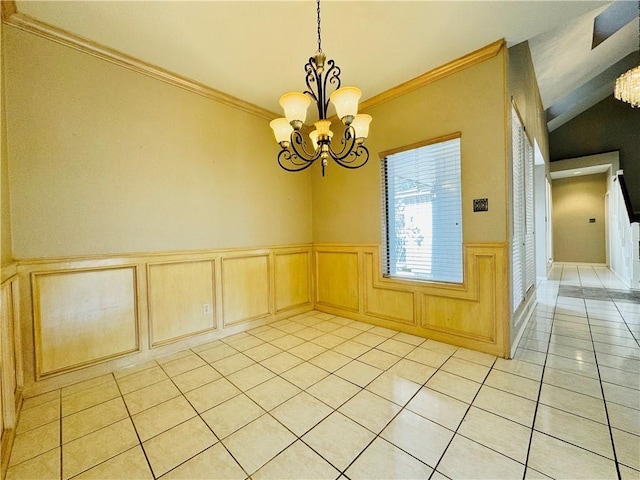 tiled spare room with lofted ceiling, ornamental molding, and a chandelier