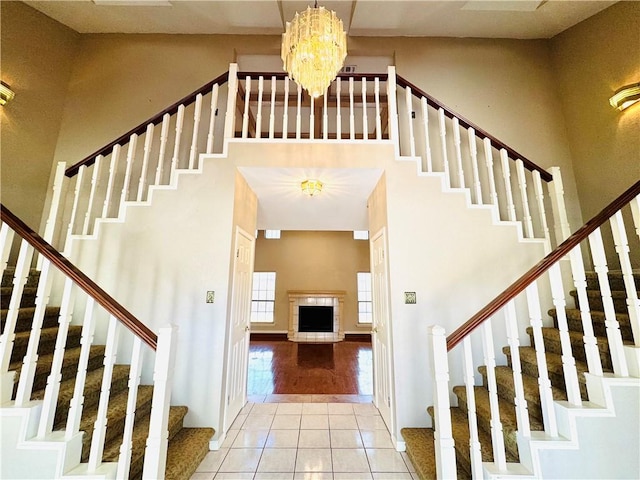 6242 Strasbourg Dr, Corpus Christi, TX 78414 - stairs featuring tile patterned flooring, a high ceiling, a chandelier, and a fireplace