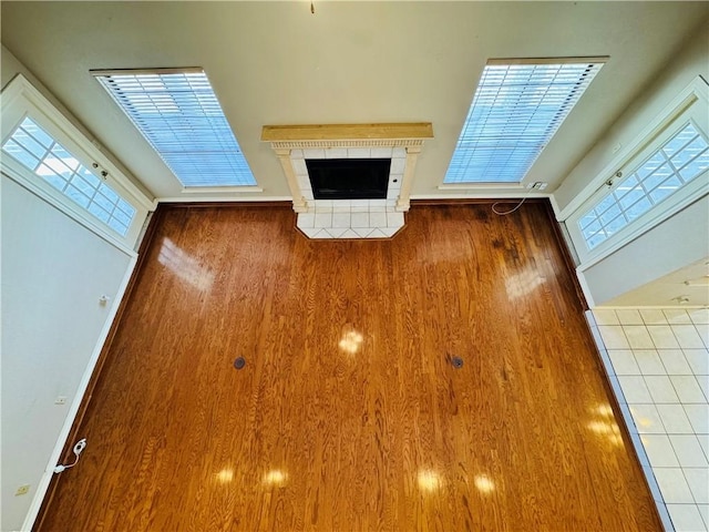 unfurnished living room featuring dark hardwood / wood-style floors, a wealth of natural light, and a fireplace