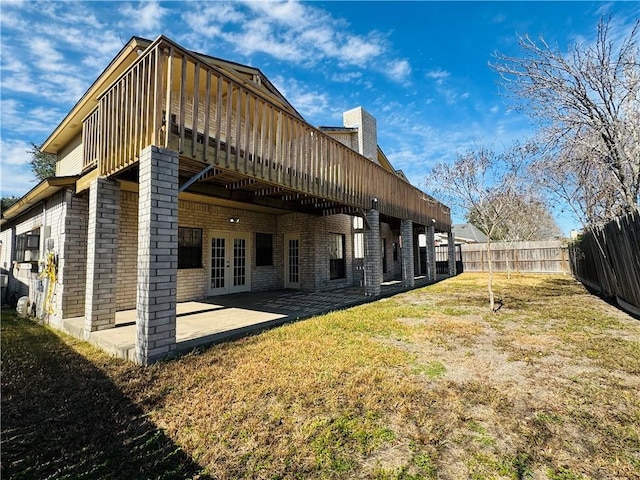 rear view of property featuring a patio, a yard, and french doors