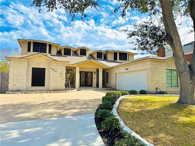 view of front of property with french doors, a garage, and a front yard