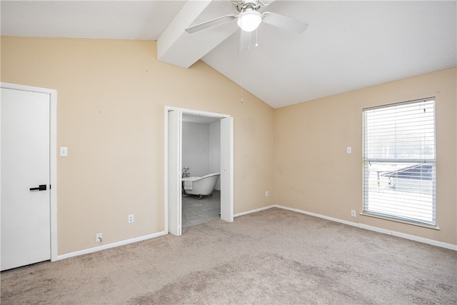 unfurnished bedroom featuring lofted ceiling with beams, light colored carpet, ceiling fan, and ensuite bath