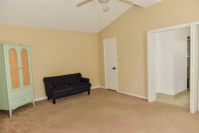 living area featuring lofted ceiling, light carpet, and ceiling fan