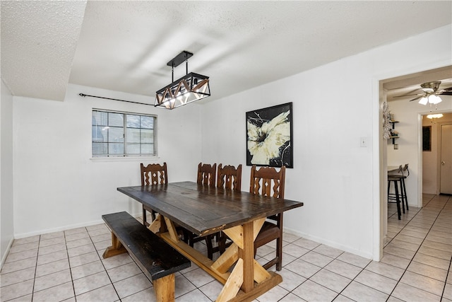 tiled dining space featuring a textured ceiling and ceiling fan