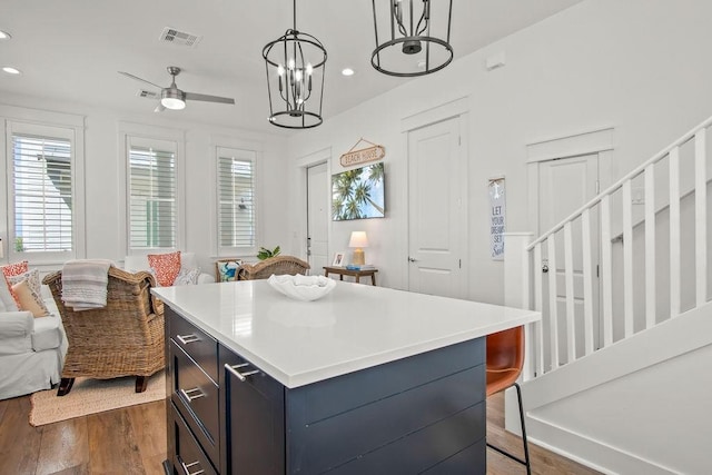 kitchen with visible vents, a center island, dark wood finished floors, open floor plan, and light countertops