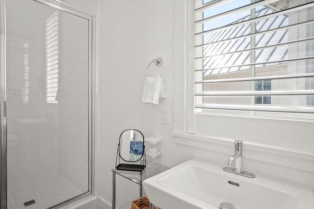 full bath with a sink and a shower stall