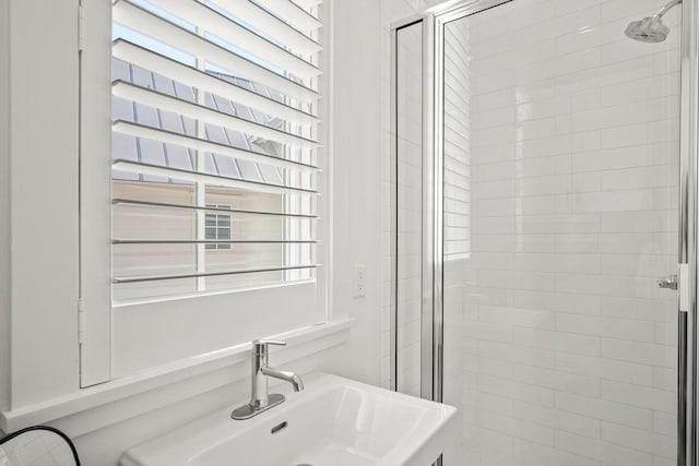 bathroom featuring a stall shower and a sink