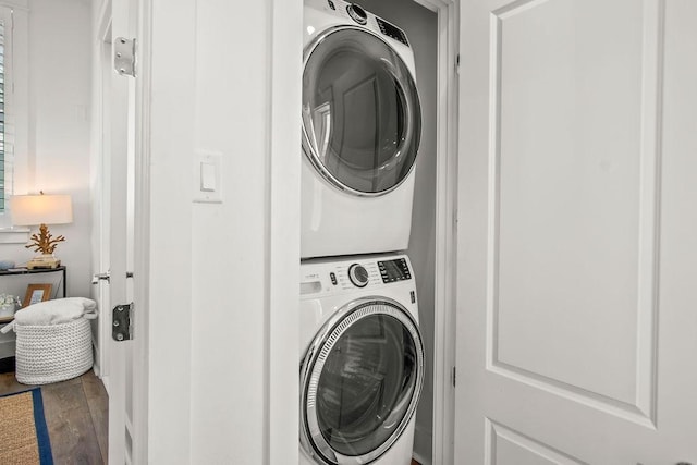 laundry area featuring stacked washer / dryer, laundry area, and wood finished floors