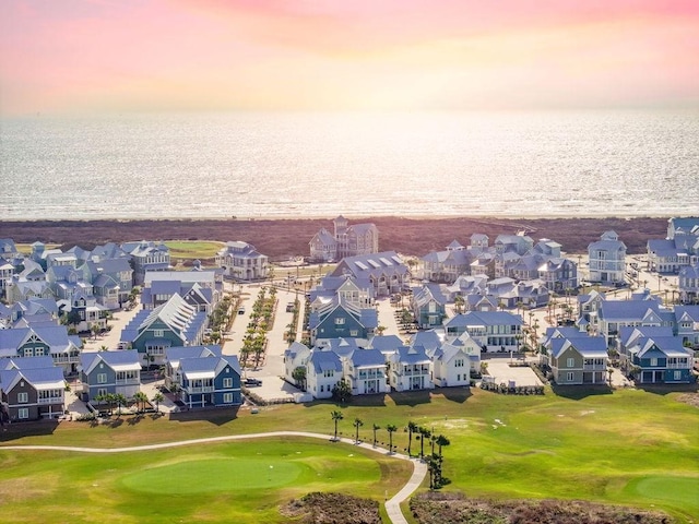 aerial view at dusk with a residential view, a water view, and golf course view