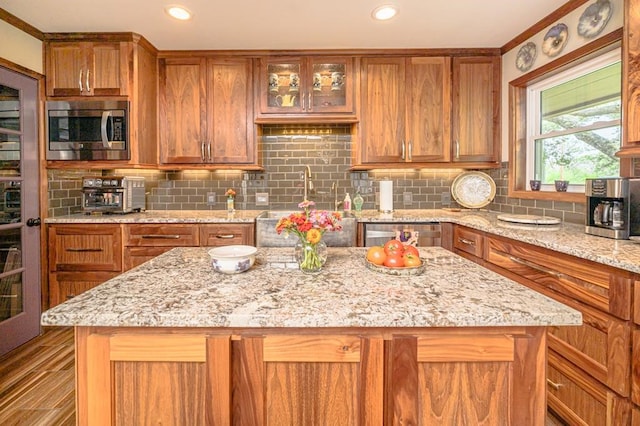 161 Red Bird Rdg, Beeville, TX 78102 - kitchen featuring stainless steel microwave, brown cabinetry, backsplash, a kitchen island, and recessed lighting
