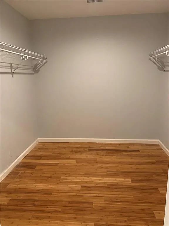 walk in closet with hardwood / wood-style floors