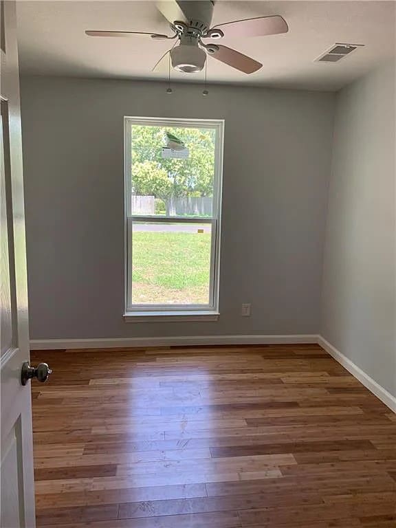 spare room with wood-type flooring and ceiling fan