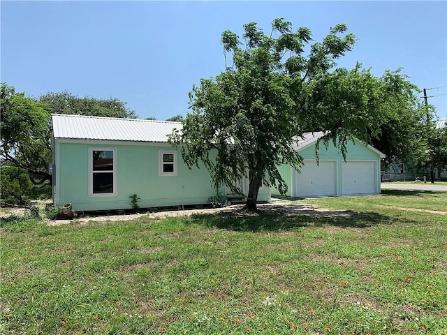 view of side of property featuring a garage and a lawn