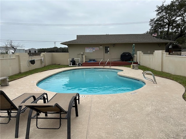 community pool featuring a fenced backyard and a patio