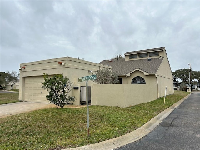 view of front of home featuring stucco siding, fence, a garage, driveway, and a front lawn