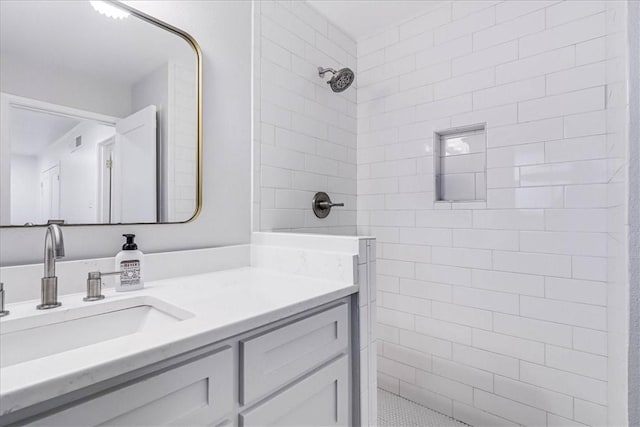 bathroom featuring a tile shower and vanity