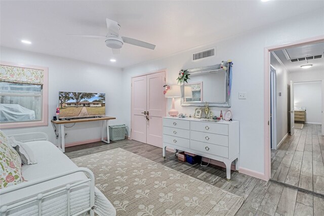 bedroom with ceiling fan, light wood-type flooring, and a closet