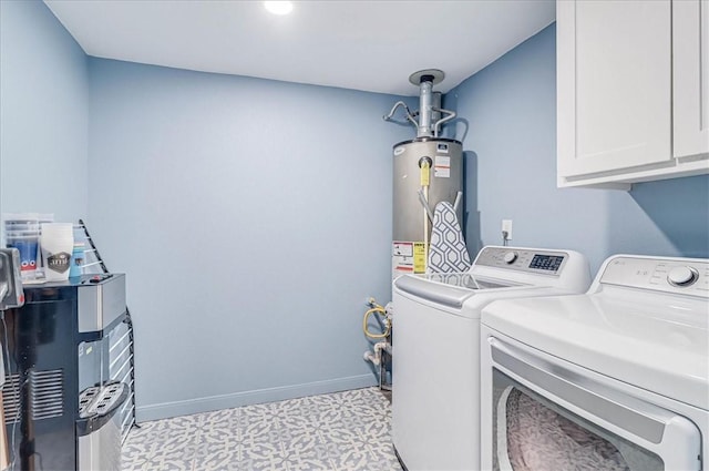 washroom featuring water heater, washing machine and clothes dryer, and cabinets