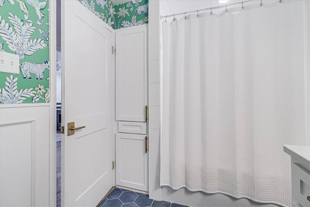 bathroom with shower / tub combo with curtain and tile patterned floors