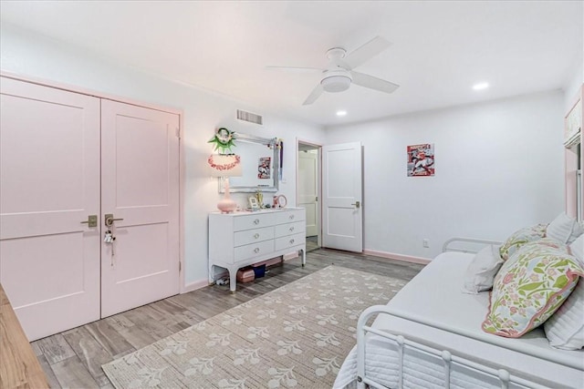 bedroom with ceiling fan, light hardwood / wood-style floors, and a closet