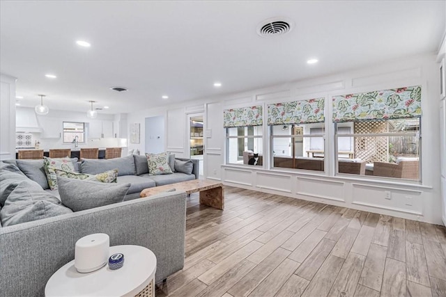 living room with light wood-type flooring and sink