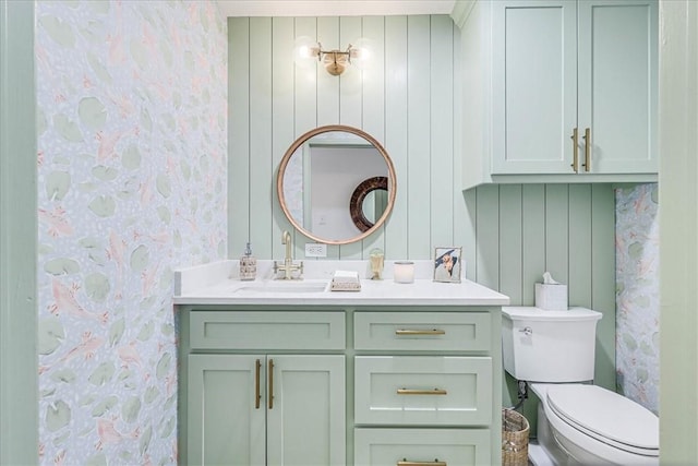 bathroom featuring toilet, wooden walls, and vanity