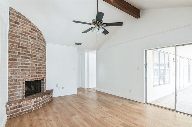 unfurnished living room with lofted ceiling with beams, wood finished floors, visible vents, a ceiling fan, and a brick fireplace