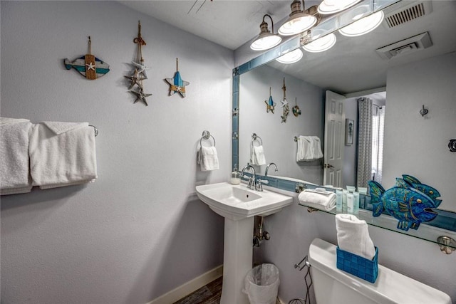 bathroom with hardwood / wood-style flooring and toilet