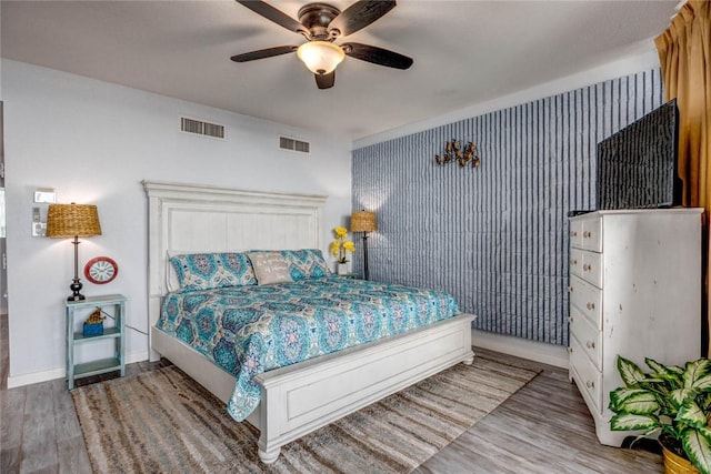 bedroom with ceiling fan and wood-type flooring