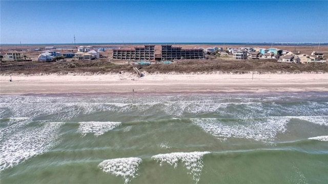 drone / aerial view with a water view and a beach view