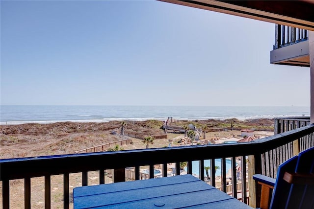 wooden terrace featuring a water view and a view of the beach