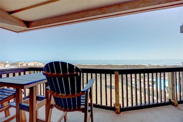 balcony featuring a beach view and a water view