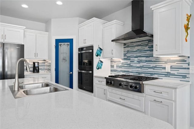 108 Bayshore Drive, Ingleside On The Bay, TX 78362 - kitchen featuring wall chimney exhaust hood, a sink, appliances with stainless steel finishes, white cabinetry, and recessed lighting