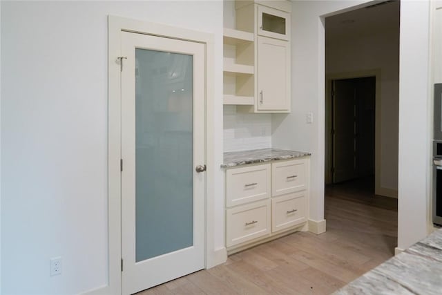 3525 Sahar Lk, Corpus Christi, TX 78380 - kitchen with light wood-style floors, light stone countertops, open shelves, white cabinets, and oven